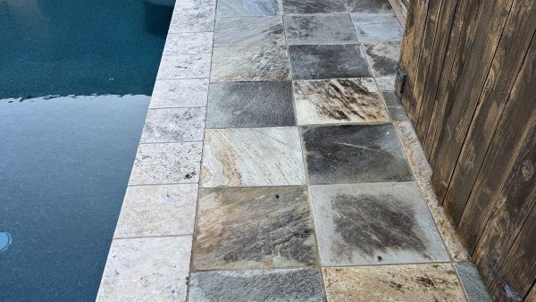 Stone pool deck before cleaning by Stonevale Exterior Co. showing dirt and buildup