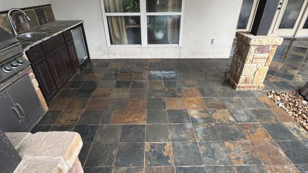 Slate tile patio with outdoor kitchen after soft washing by Stonevale Exterior Co. showing clean restored stone