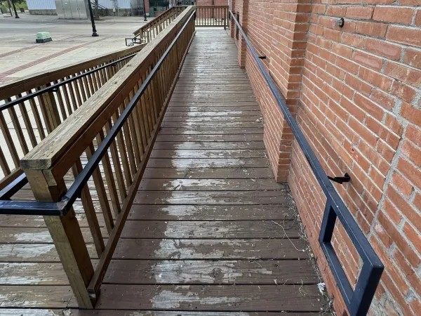 Commercial wooden deck walkway before pressure washing by Stonevale Exterior Co. in Bryan showing weathering and staining