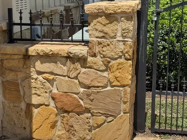 Flagstone driveway divider and pillar after cleaning by Stonevale Exterior Co. showing clean warm-toned stone