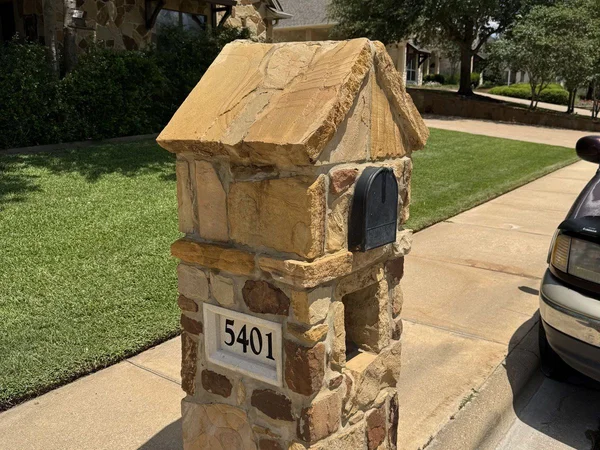 Stone mailbox after soft washing by Stonevale Exterior Co. showing clean warm natural stone color restored