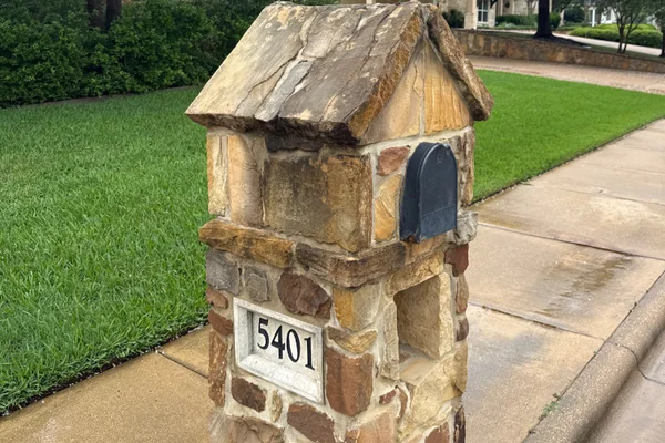 Stone mailbox before soft washing by Stonevale Exterior Co. showing dark weathered and algae-stained stone