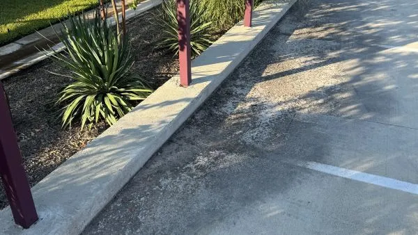 Commercial parking lot before pressure washing by Stonevale Exterior Co. showing dirt and grime buildup on curbs and surface